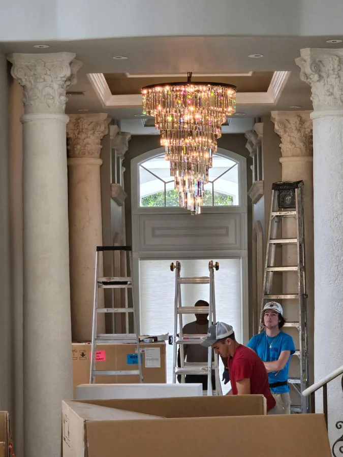 ICS crew installing the entry chandelier at 464 Addison Park Lane, Boca Raton