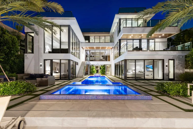 Modern waterfront estate and pool at dusk